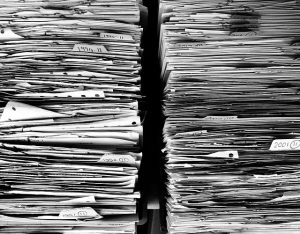 Two stacks of old paperwork representing fragmented digital evidence
